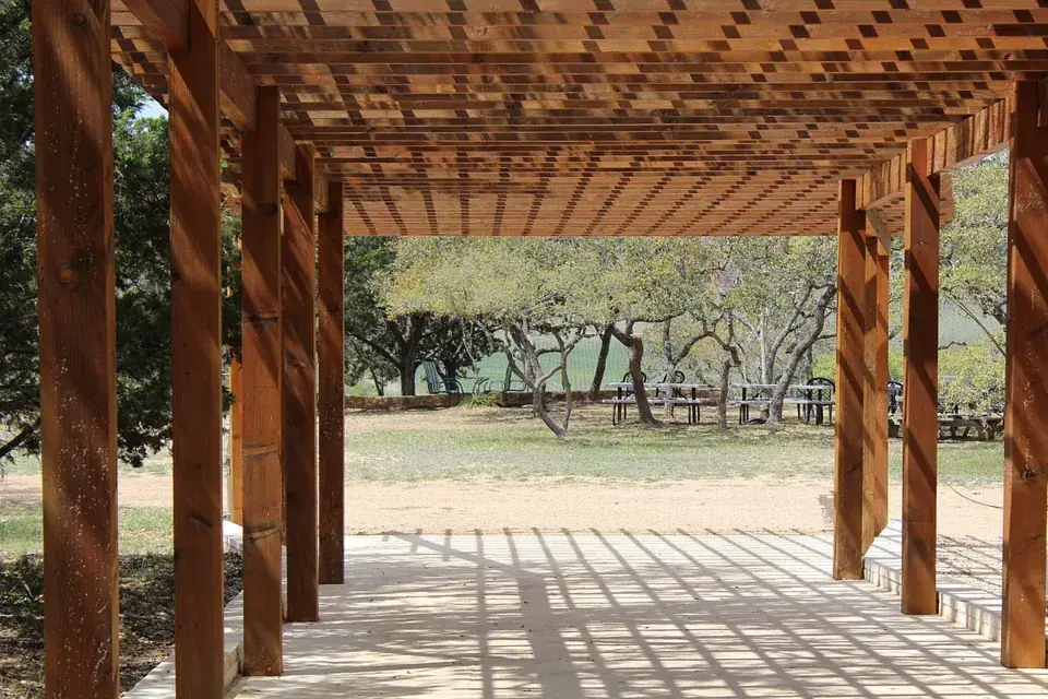 Dřevěná pergola s trámovým roštem na zahradě